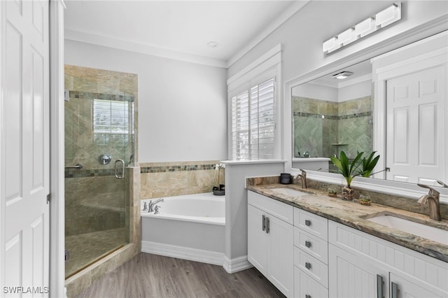 bathroom with vanity, wood-type flooring, ornamental molding, and plus walk in shower