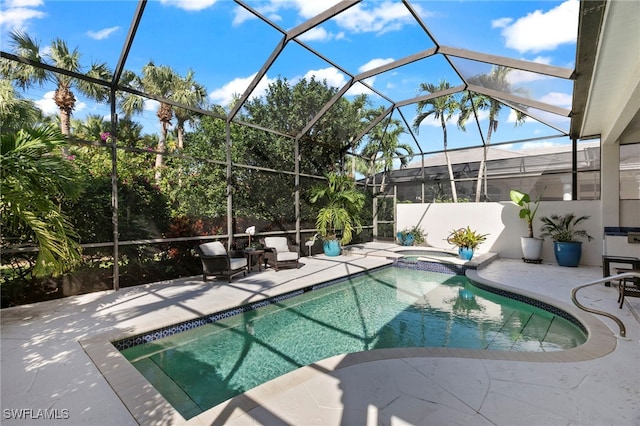 view of pool with glass enclosure, a patio area, and an in ground hot tub