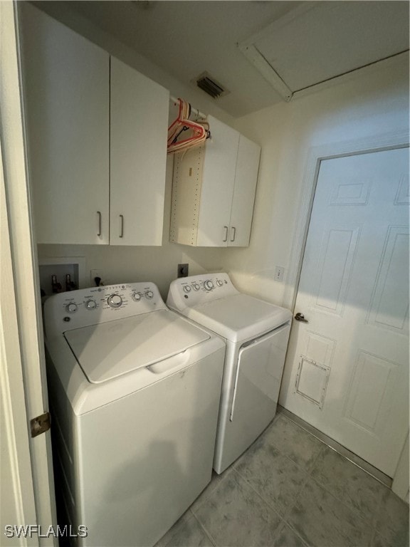 washroom featuring cabinets and washing machine and clothes dryer