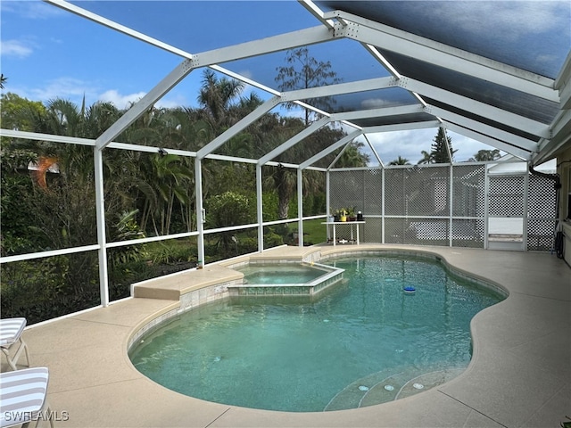 view of pool with a lanai, a patio area, and an in ground hot tub