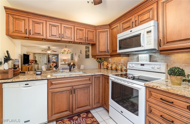 kitchen featuring decorative backsplash, white appliances, sink, and light tile patterned floors