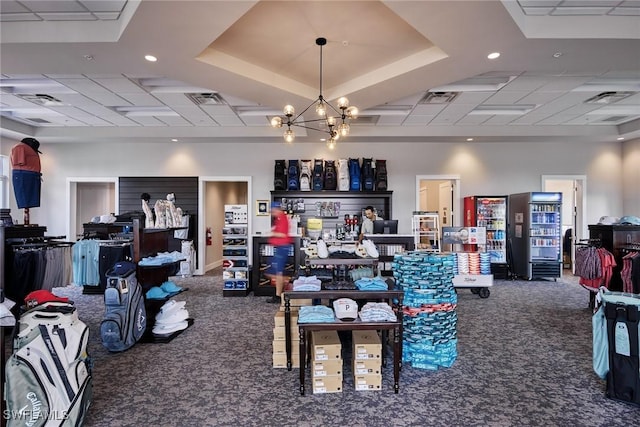 misc room featuring an inviting chandelier, a paneled ceiling, and dark carpet