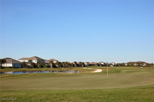 surrounding community featuring a water view and a lawn