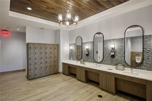 bathroom with wood-type flooring, tasteful backsplash, a raised ceiling, and vanity