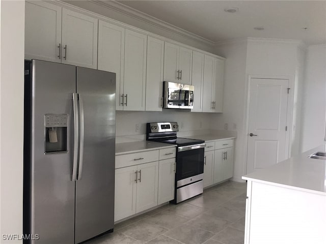 kitchen featuring white cabinetry, light tile patterned floors, ornamental molding, and stainless steel appliances