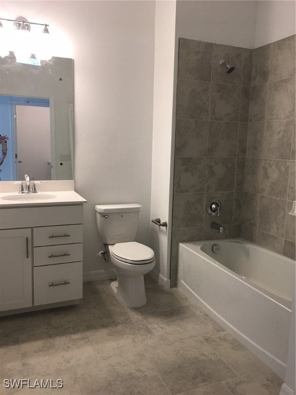 full bathroom featuring vanity, tiled shower / bath, and toilet