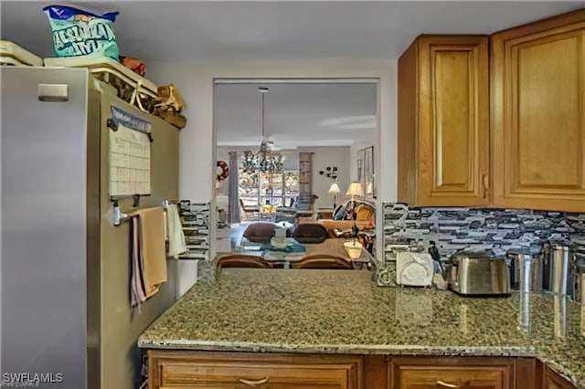 kitchen featuring decorative backsplash and light stone countertops