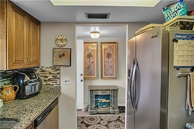 kitchen featuring stainless steel refrigerator with ice dispenser and stone countertops