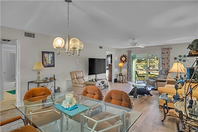 living room featuring ceiling fan with notable chandelier