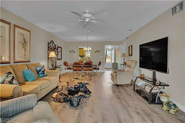 living room featuring hardwood / wood-style floors and ceiling fan with notable chandelier