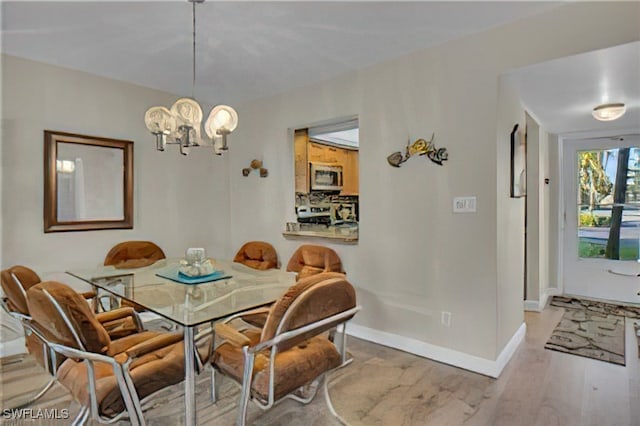 dining room with wood-type flooring and a notable chandelier