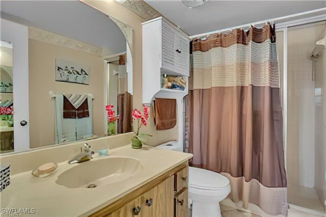 bathroom with vanity, curtained shower, and toilet