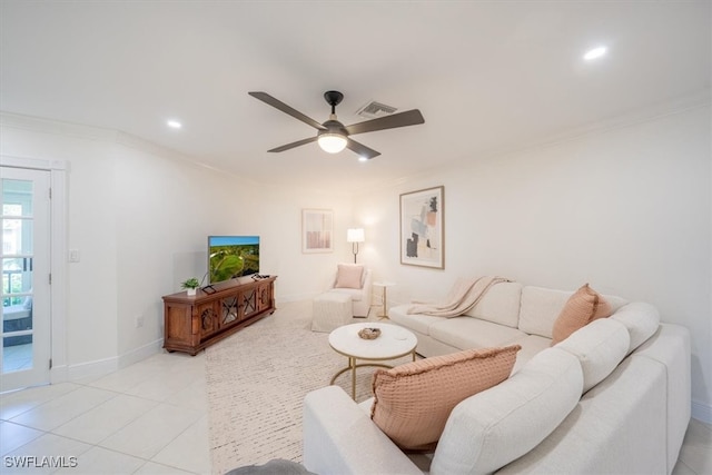 living room with light tile patterned floors, visible vents, baseboards, a ceiling fan, and ornamental molding