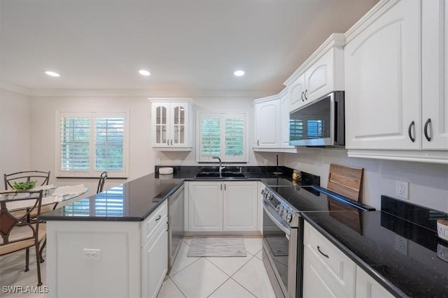 kitchen with appliances with stainless steel finishes, white cabinets, and a sink