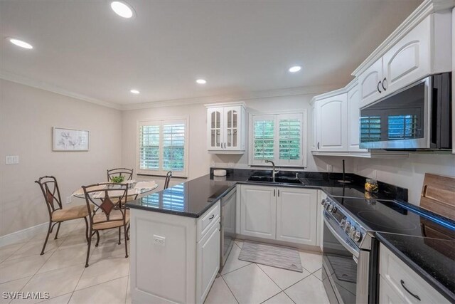 kitchen with appliances with stainless steel finishes, a wealth of natural light, white cabinets, and a sink