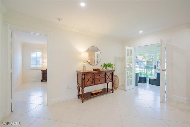 hallway featuring french doors, ornamental molding, plenty of natural light, and baseboards