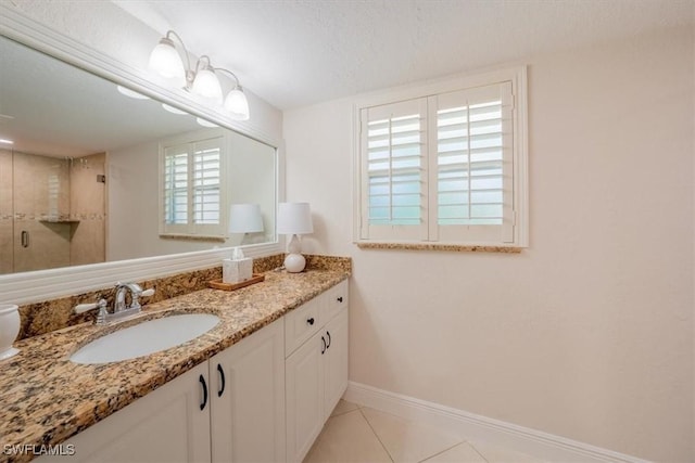 bathroom featuring a shower stall, vanity, baseboards, and tile patterned floors