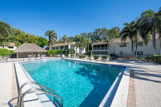 community pool with a patio and fence