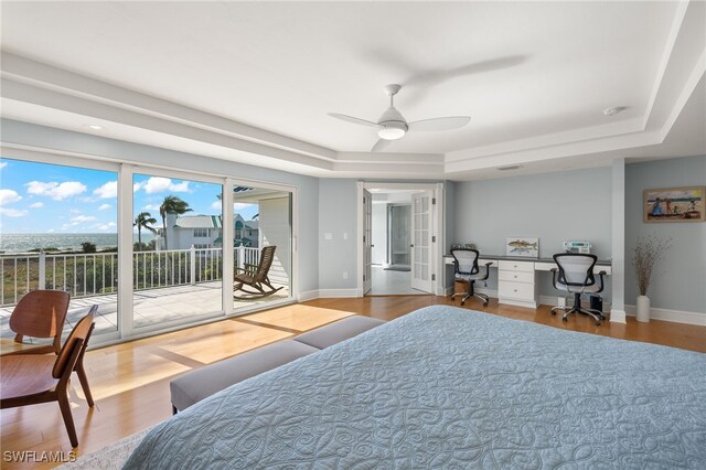 411 Bella Vista Way E, Sanibel, FL 33957 - bedroom with a raised ceiling, access to exterior, wood finished floors, and baseboards
