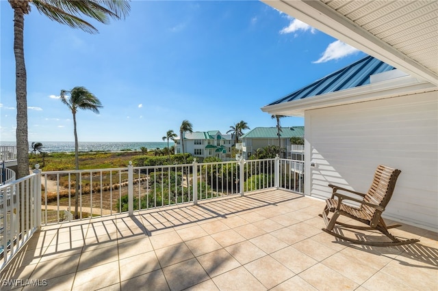 view of patio with a water view and a balcony