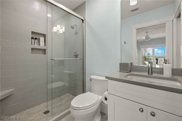 bathroom with vanity, toilet, and a shower with shower door