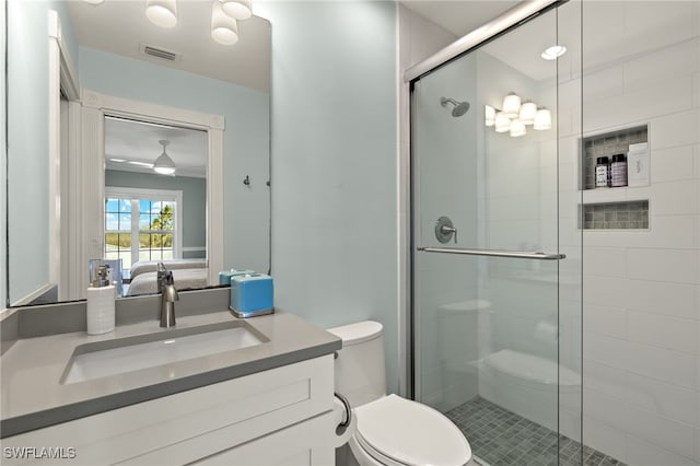 bathroom featuring tile patterned flooring, vanity, toilet, and a shower with shower door