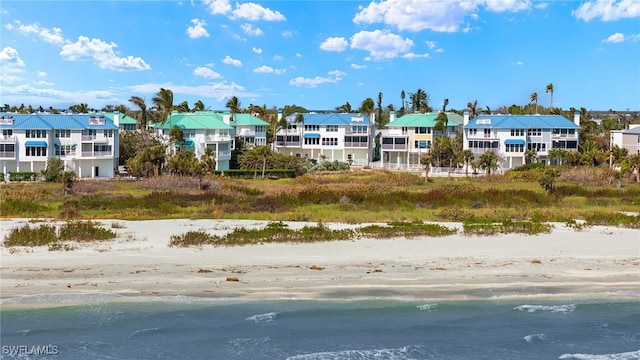 birds eye view of property with a water view and a view of the beach