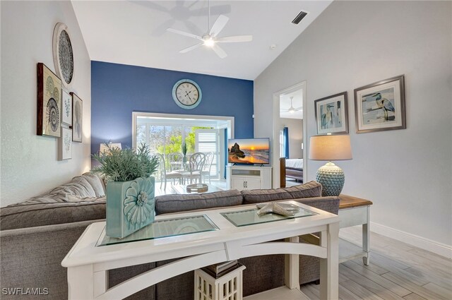 home office with ceiling fan, lofted ceiling, and light hardwood / wood-style flooring