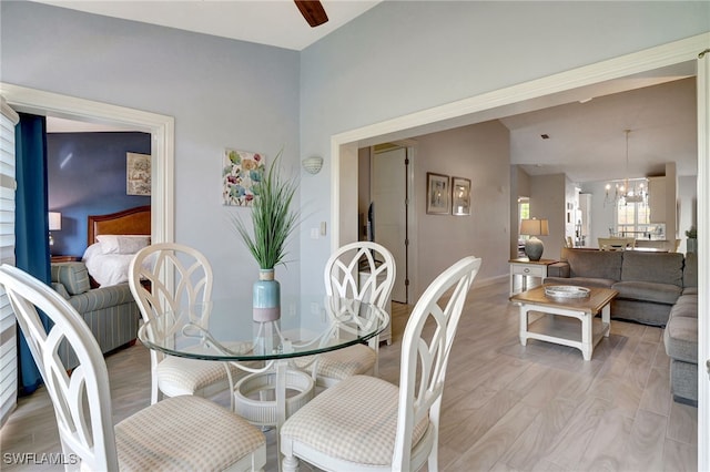 dining room featuring ceiling fan with notable chandelier and light wood-type flooring