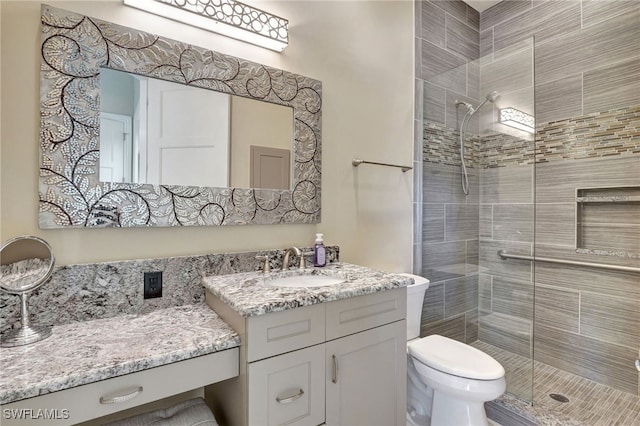 bathroom featuring vanity, toilet, and a shower with shower door