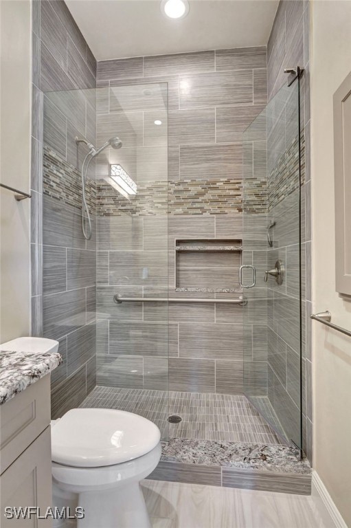 bathroom with vanity, an enclosed shower, and toilet