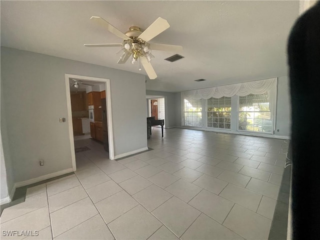 empty room with light tile patterned floors and ceiling fan