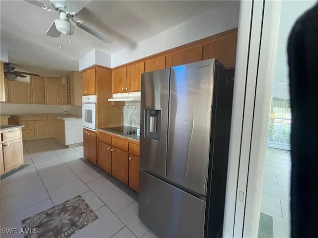 kitchen featuring stainless steel fridge with ice dispenser, light tile patterned floors, ceiling fan, black electric stovetop, and oven