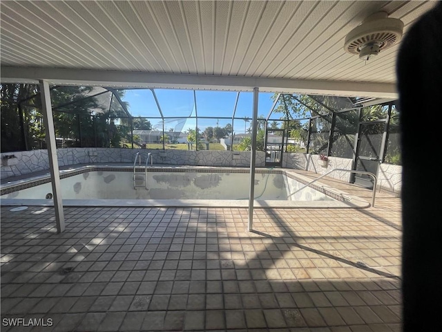 view of swimming pool with a lanai and a patio