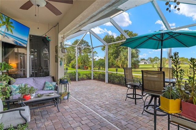 view of patio / terrace featuring glass enclosure and ceiling fan