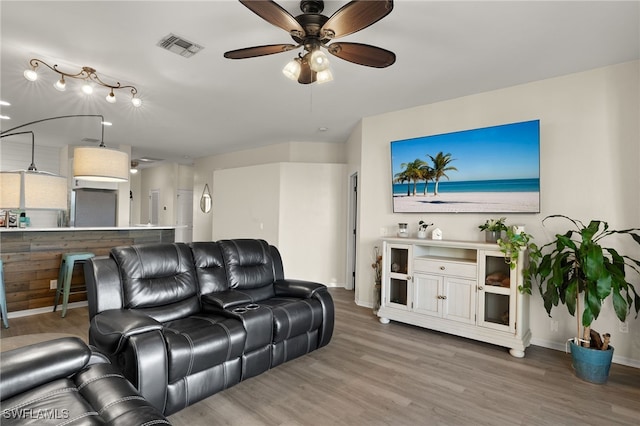 living room with wood-type flooring and ceiling fan