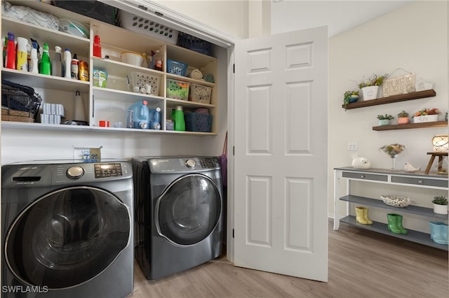 washroom featuring washer and clothes dryer and light hardwood / wood-style floors