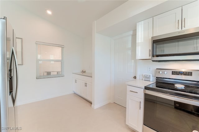 kitchen featuring white cabinetry, stainless steel appliances, and lofted ceiling