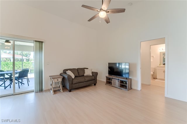 living room featuring a towering ceiling and light hardwood / wood-style flooring