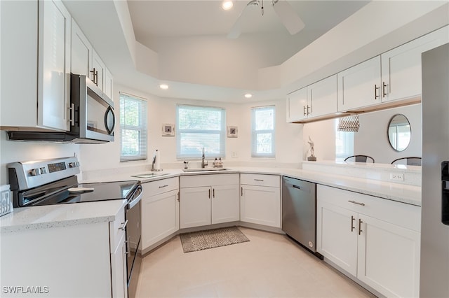 kitchen featuring sink, ceiling fan, white cabinetry, kitchen peninsula, and stainless steel appliances