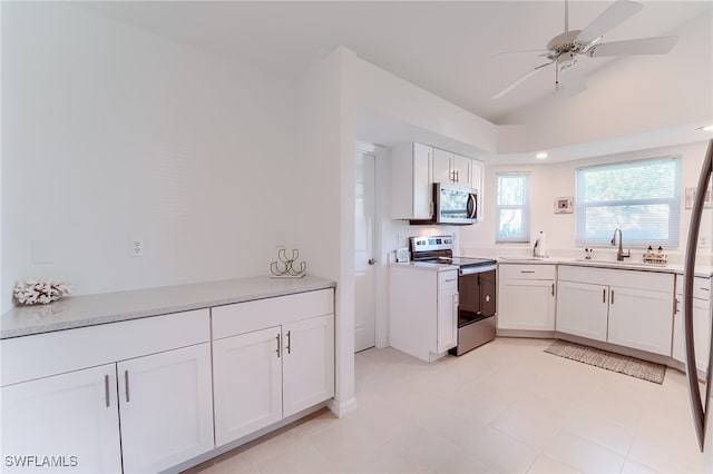 kitchen featuring appliances with stainless steel finishes, ceiling fan, sink, white cabinetry, and lofted ceiling