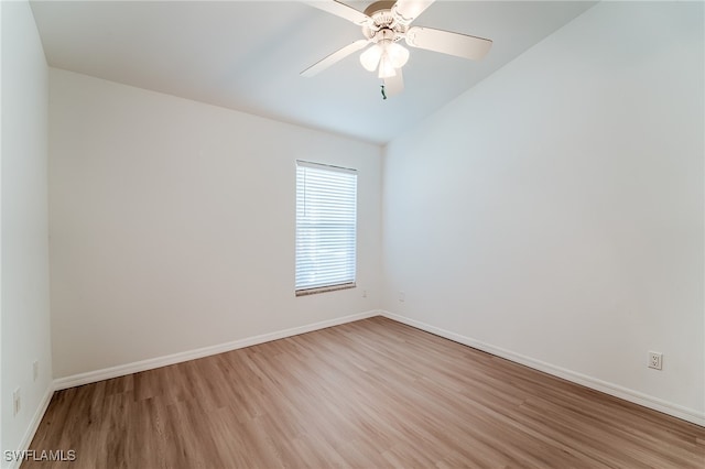 spare room with ceiling fan, vaulted ceiling, and light hardwood / wood-style flooring