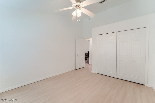 unfurnished bedroom featuring ceiling fan, a closet, and light wood-type flooring