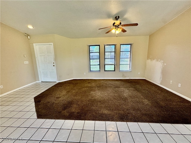 carpeted empty room with ceiling fan and a textured ceiling