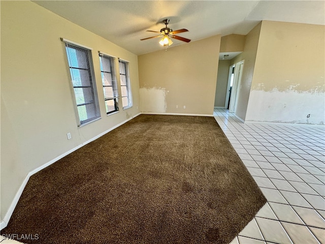 unfurnished room featuring ceiling fan, light tile patterned flooring, and vaulted ceiling