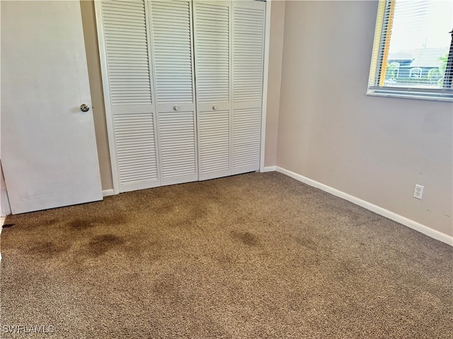 unfurnished bedroom featuring carpet floors and a closet