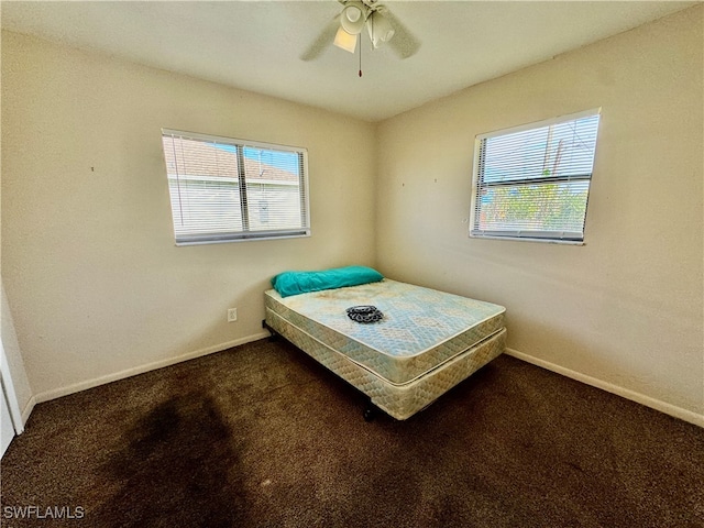 unfurnished bedroom featuring dark colored carpet and ceiling fan