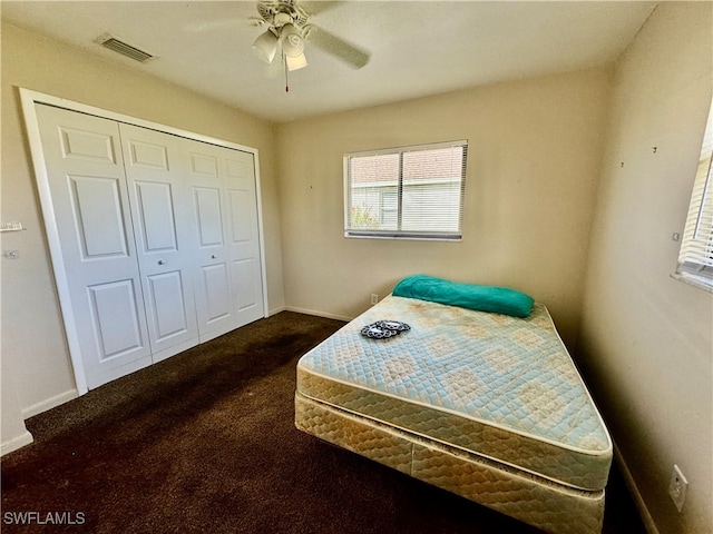 bedroom with ceiling fan, a closet, and dark carpet