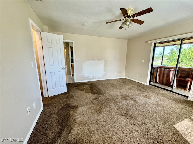 spare room with dark carpet and ceiling fan