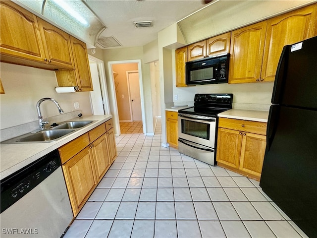 kitchen featuring black appliances, light tile patterned floors, and sink